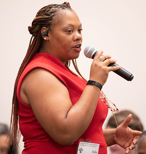 Ada Webb speaks into microphone at community associate retreat