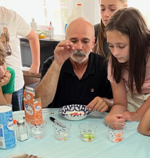 Isaias Alezones shows children a STEM experiment in Choctaw County.